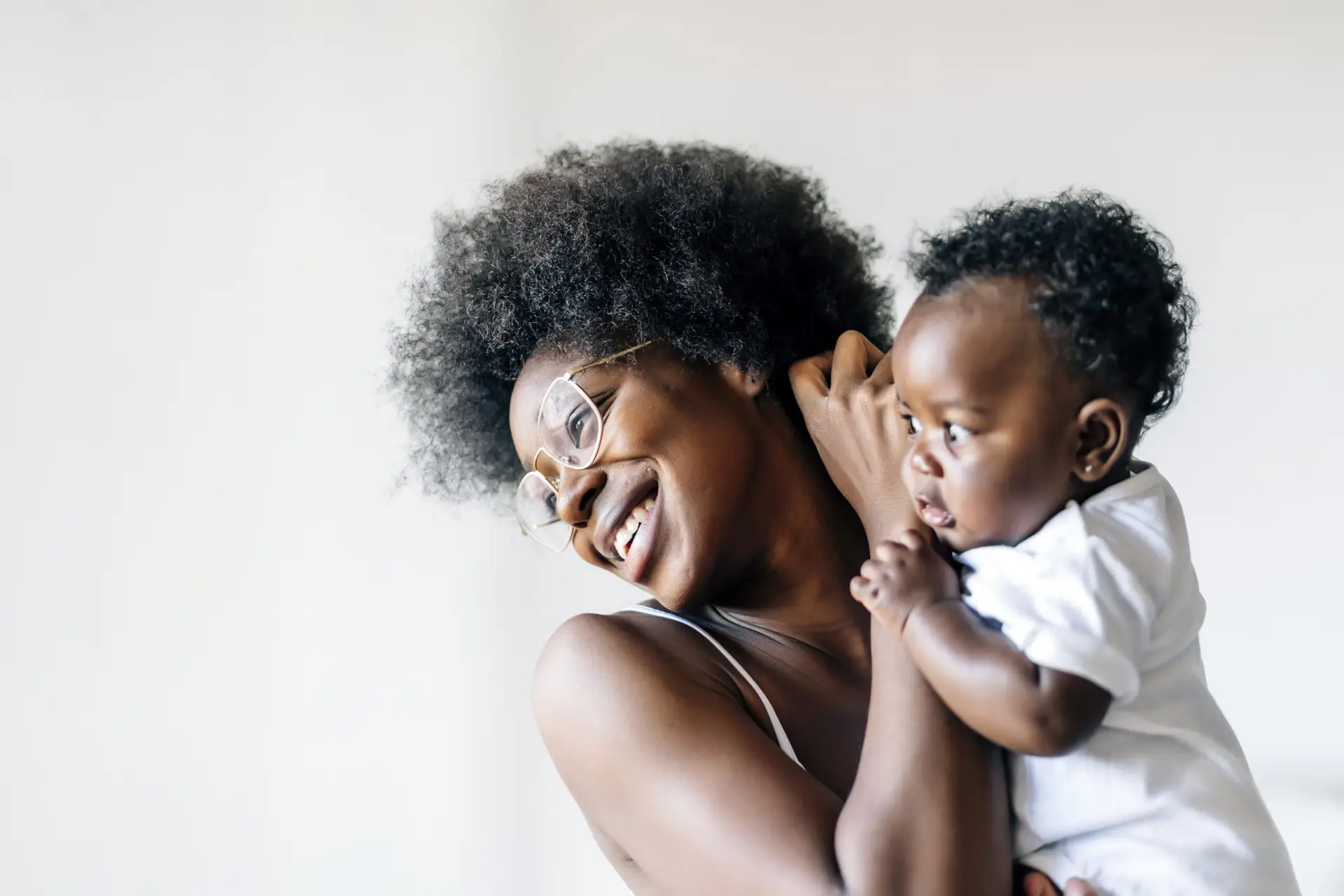 african american mother taking care and loving her baby against a white background